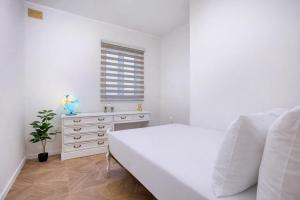 a white bedroom with a bed and a dresser at NEW - Unique 3BR Apartment in Sought-After Area of Malta by SF Homes in Hal Ghaxiak