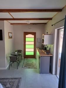 a kitchen with a table and a green door at Fig Tree in Colesberg