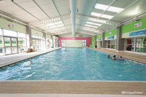 a large indoor swimming pool with people in it at Seaside Caravan Home in Reighton
