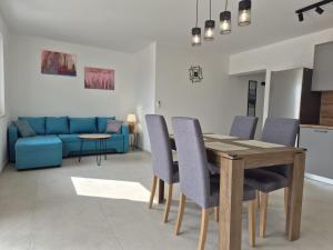 a dining room and living room with a wooden table and chairs at Apartment Natalija A2 ground floor in Krk