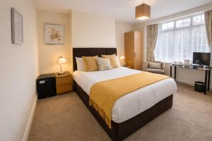 a bedroom with a bed and a chair and a window at Hampton Lodge En-Suite Rooms with Free Parking in Stratford-upon-Avon +8 photos