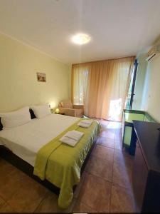 a bedroom with a large bed with a green blanket at Family hotel Apolon in Nesebar +37 photos