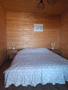 a bedroom with a bed in a wooden room at Pod Dębem in Winnica