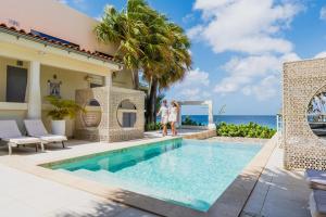 a villa with a swimming pool and the ocean at Boutique Hotel Bougainvillea in Kralendijk