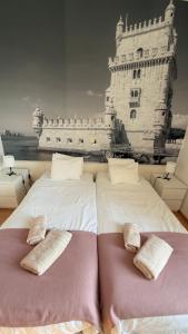 two beds with pillows in front of a large building at Lisboa II Hotel Restaurant in Luxembourg