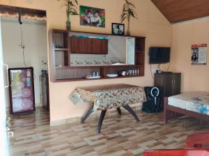 a living room with a table and a tv at Airin's Villa in Agali