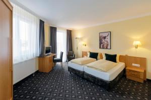 a hotel room with a bed and a desk at Hotel Zum Adler in Nidderau