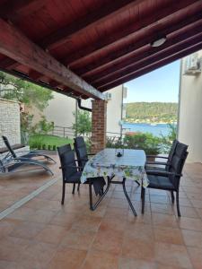 a table and chairs on a patio with a view at Apartments Poljak in Supetarska Draga