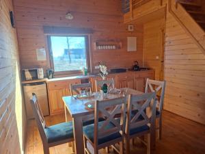 a dining room with a table and chairs in a cabin at Pod Dębem in Winnica