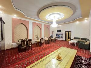 a large room with chairs and a table and a couch at Khiva Tosh Darvoza & Trip service in Khiva