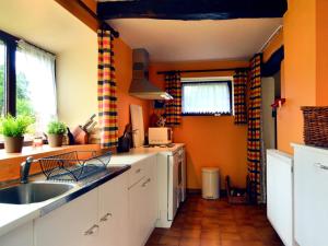 cocina con paredes de color naranja y fregadero en Vintage Cottage with Shared Garden in Paliseul, en Paliseul