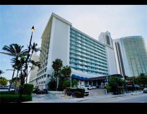 a large building in a city with palm trees and buildings at Condo-Hotel on Collins ave in Sunny Isles Beach