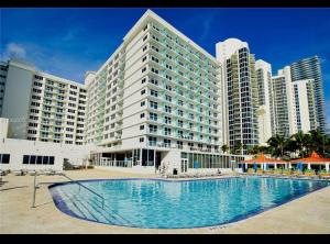 a large apartment building with a large swimming pool at Condo-Hotel on Collins ave in Sunny Isles Beach