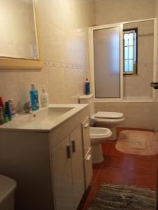 a bathroom with a sink and a toilet and a window at Quarto no Sótão in Coruche +43 photos
