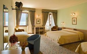 a hotel room with two beds and a table at Albergo Bellavista in Limone sul Garda +91 photos