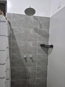 a shower with a shower head in a bathroom at Furahi Apartment in Mombasa +35 photos