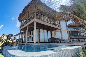 a house with a swimming pool in front of a house at BobZ Boutique Resort in Barra Grande