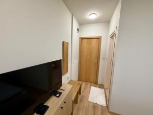 a room with a television and a wooden door at Boutique Rooms Desi 3 in Pleven