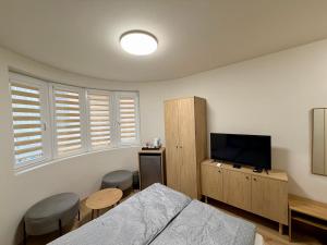 a bedroom with a bed and a flat screen tv at Boutique Rooms Desi 3 in Pleven