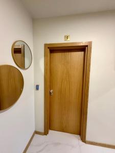 a wooden door in a room with a mirror at Boutique Rooms Desi 3 in Pleven