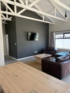 a living room with a couch and a flat screen tv at House Stillmar in Walvis Bay