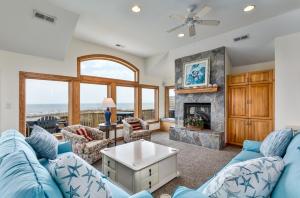 a living room with a blue couch and a fireplace at 2440 - Solitude South in Duck