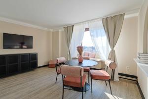 a living room with a table and chairs and a window at KasselRooms Comfort Studio in Kassel
