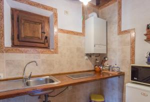 a small kitchen with a sink and a microwave at LA DEHESILLA in Madriguera +50 photos