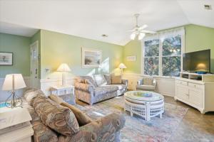 a living room with a couch and a tv at 4620 - Flip Flop Inn in Southern Shores