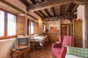 a living room with a tv and a couch and a table at LA DEHESILLA in Madriguera