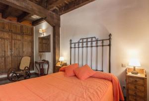 a bedroom with an orange bed and a chair at LA DEHESILLA in Madriguera