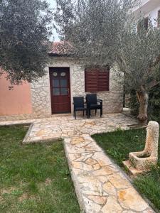 a patio with two chairs and a red door at Kata in Privlaka