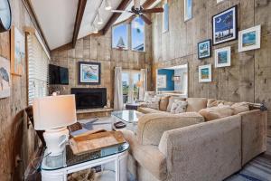 a living room with a couch and a tv at 3979 - Wright by the Coast in Duck