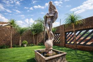 a statue of a woman standing on top of a fountain at Caesars Place Guest House in Kathu