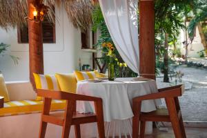a table with chairs and a vase of flowers on it at Mikasa Bacalar Hotel Boutique, Lagoon Front in Bacalar +22 photos