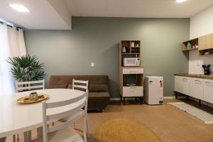 a kitchen and living room with a table and a couch at P&G Apto 202-San Gimignano in Caxias do Sul
