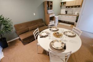 a living room with a white table and chairs at P&G Apto 202-San Gimignano in Caxias do Sul +5 photos