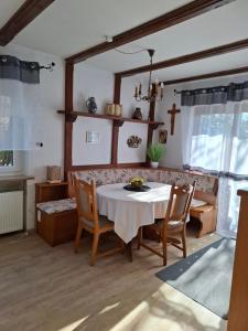 a dining room with a white table and chairs at Ferienwohnung Rose in Altenkunstadt