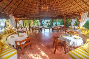 a restaurant with tables and couches and chairs at Mikasa Bacalar Hotel Boutique, Lagoon Front in Bacalar