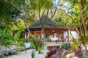 a pavilion in the middle of a forest with trees at Mikasa Bacalar Hotel Boutique, Lagoon Front in Bacalar