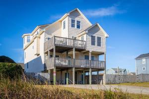 a large house with balconies on a beach at 5195 - Captain's Choice in Kill Devil Hills