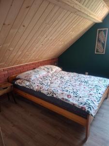 a bed in a room with a wooden ceiling at Domek na Podgrabiu in Łącko