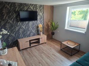 a living room with a television on a wall at Domek na Podgrabiu in Łącko