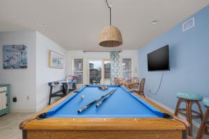 a room with a pool table with cuesticks on it at 5468 - Mermaids' Lagoon in Nags Head