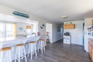 a kitchen with a counter and stools in a room at 7847 - Summerset in Frisco +33 photos