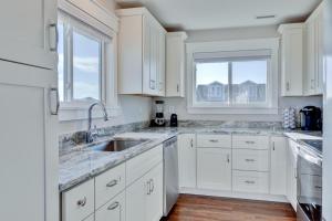 a white kitchen with white cabinets and a sink at 4740 - August's Summer Place in Kitty Hawk Beach +22 photos
