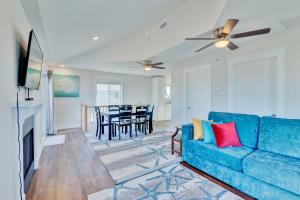 a living room with a blue couch and a dining room at 4740 - August's Summer Place in Kitty Hawk Beach