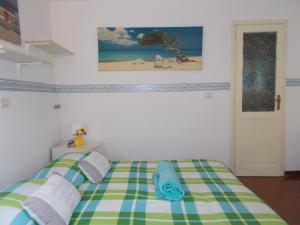 1 dormitorio con 1 cama con manta verde y blanca en Il Granello di Senape B&B, en Palazzo Canavese