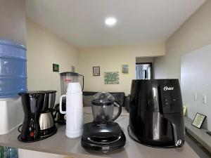 a kitchen counter with two coffee makers on a counter at Flat 1218, no residencial monte castelo in Bezerros