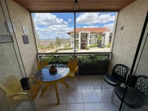 a balcony with a table and chairs and a large window at Flat 1218, no residencial monte castelo in Bezerros